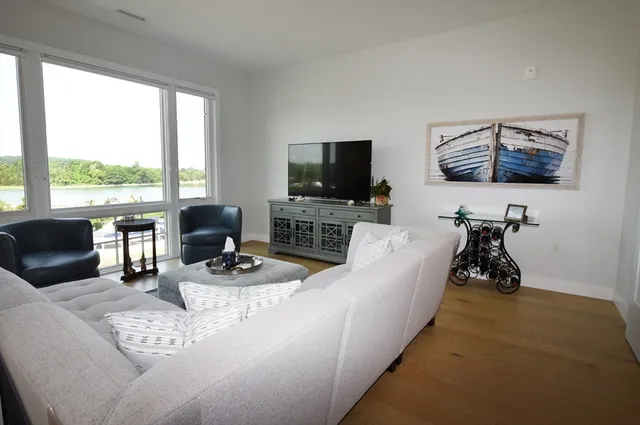 a living room with furniture a flat screen tv and a floor to ceiling window