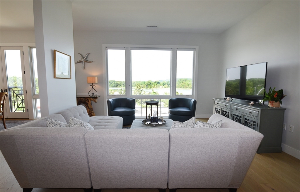 10 Shipyard Drive, Unit 313 Hingham, MA 02043 - Photo 6 of 39 a living room with furniture a flat screen tv and a large window