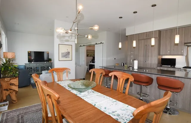 a living room with furniture a flat screen tv and kitchen view