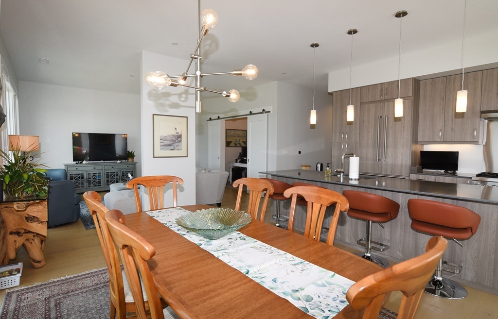 10 Shipyard Drive, Unit 313 Hingham, MA 02043 - Photo 9 of 39 a living room with furniture a flat screen tv and kitchen view