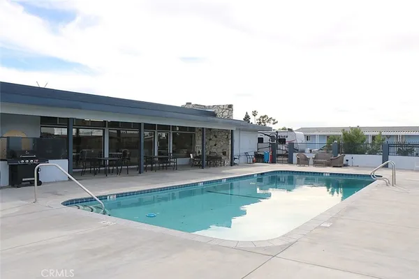 a view of a swimming pool with lawn chairs and a yard