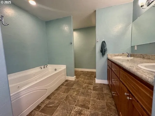 a bathroom with a tub sink and mirror