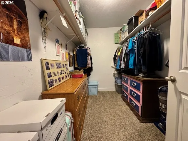 a view of walk in closet with clothes and shoes