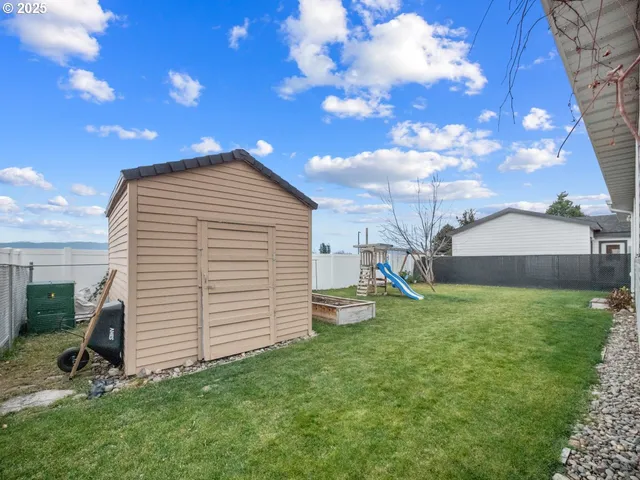 a view of a house with a yard and a tree