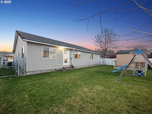 a view of a backyard with a garden and entertaining space