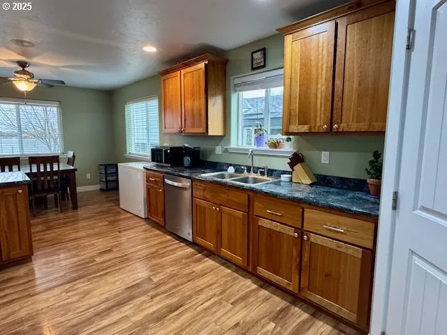a kitchen with stainless steel appliances granite countertop wooden cabinets a sink and dishwasher with wooden floor