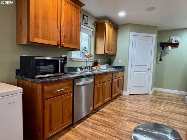a kitchen with stainless steel appliances granite countertop wooden cabinets a sink and dishwasher