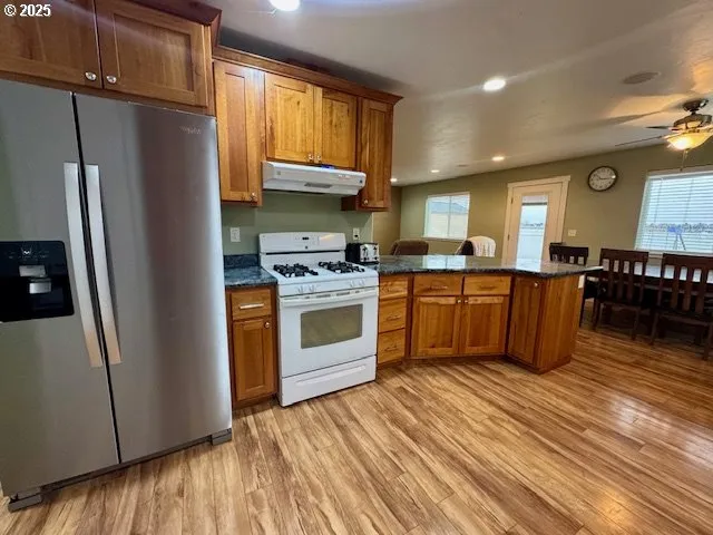 a kitchen with stainless steel appliances granite countertop a stove a sink dishwasher and a refrigerator