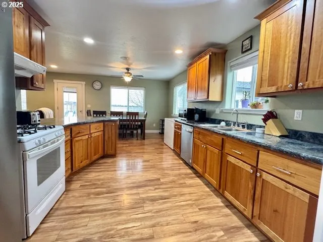 a large kitchen with stainless steel appliances granite countertop a stove a sink dishwasher and a refrigerator