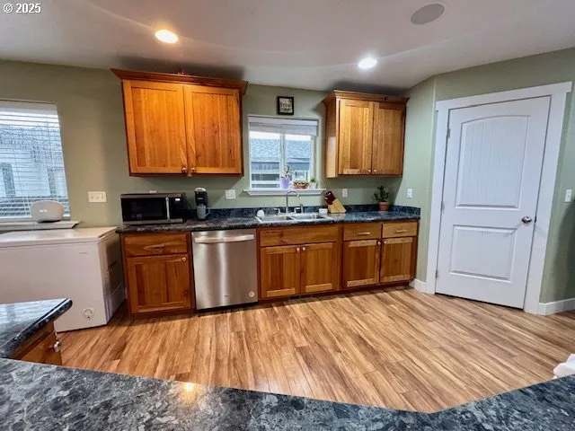 a kitchen with wooden floors cabinets a sink and appliances
