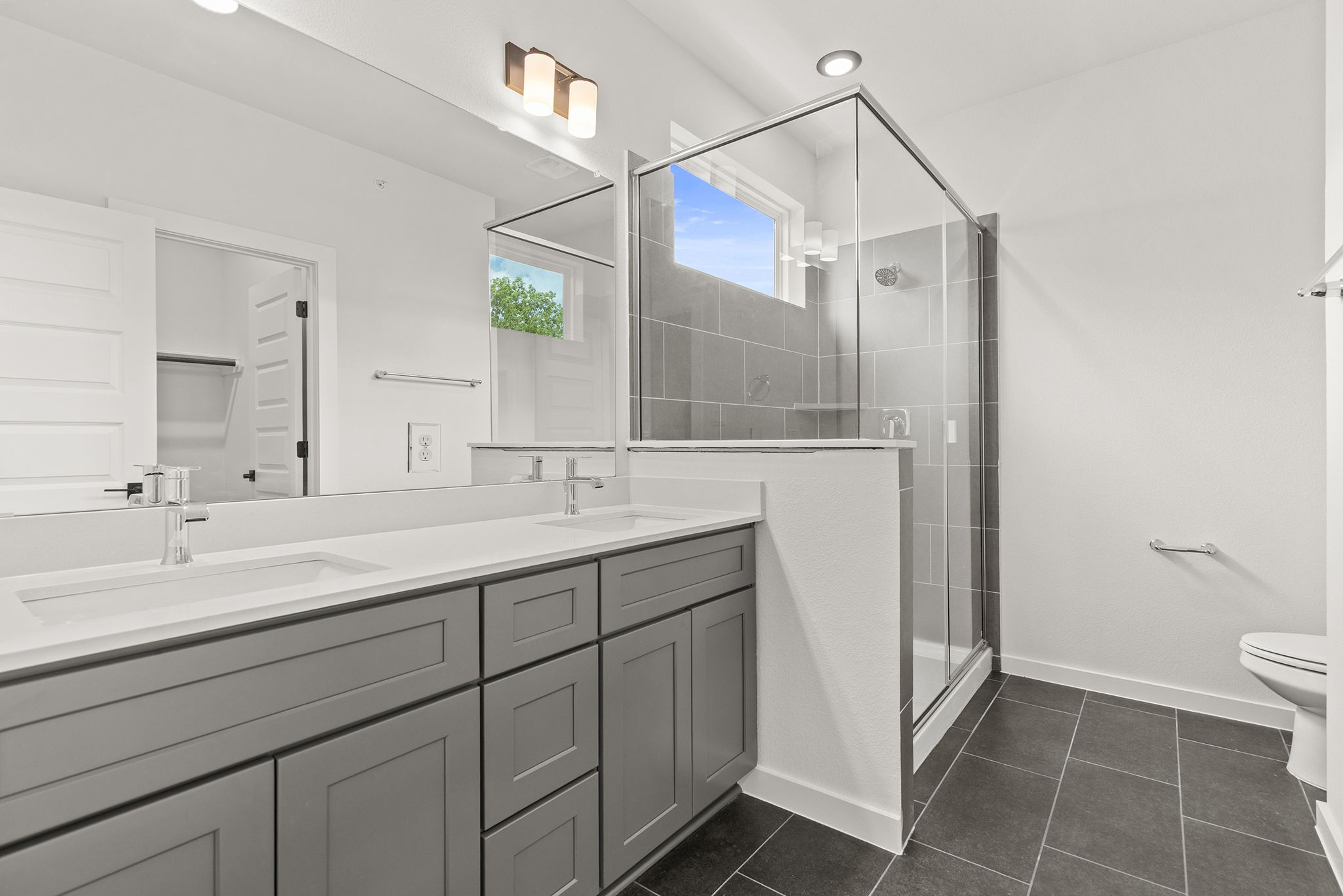 2600 Gattis School Road, Unit 1002 Round Rock, TX 78664 - Photo 21 of 40 Dual vanity sinks complement a spacious walk-in shower in this contemporary primary bathroom.
