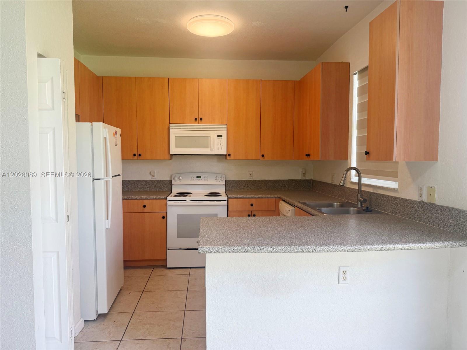 662 Northeast 21st Terrace Homestead, FL 33033 - Photo 26 of 34 a kitchen with a refrigerator and a sink
