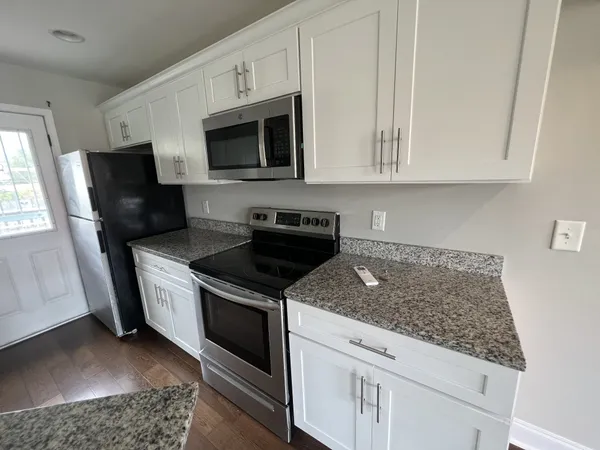 a kitchen with stainless steel appliances granite countertop a stove a microwave and a sink