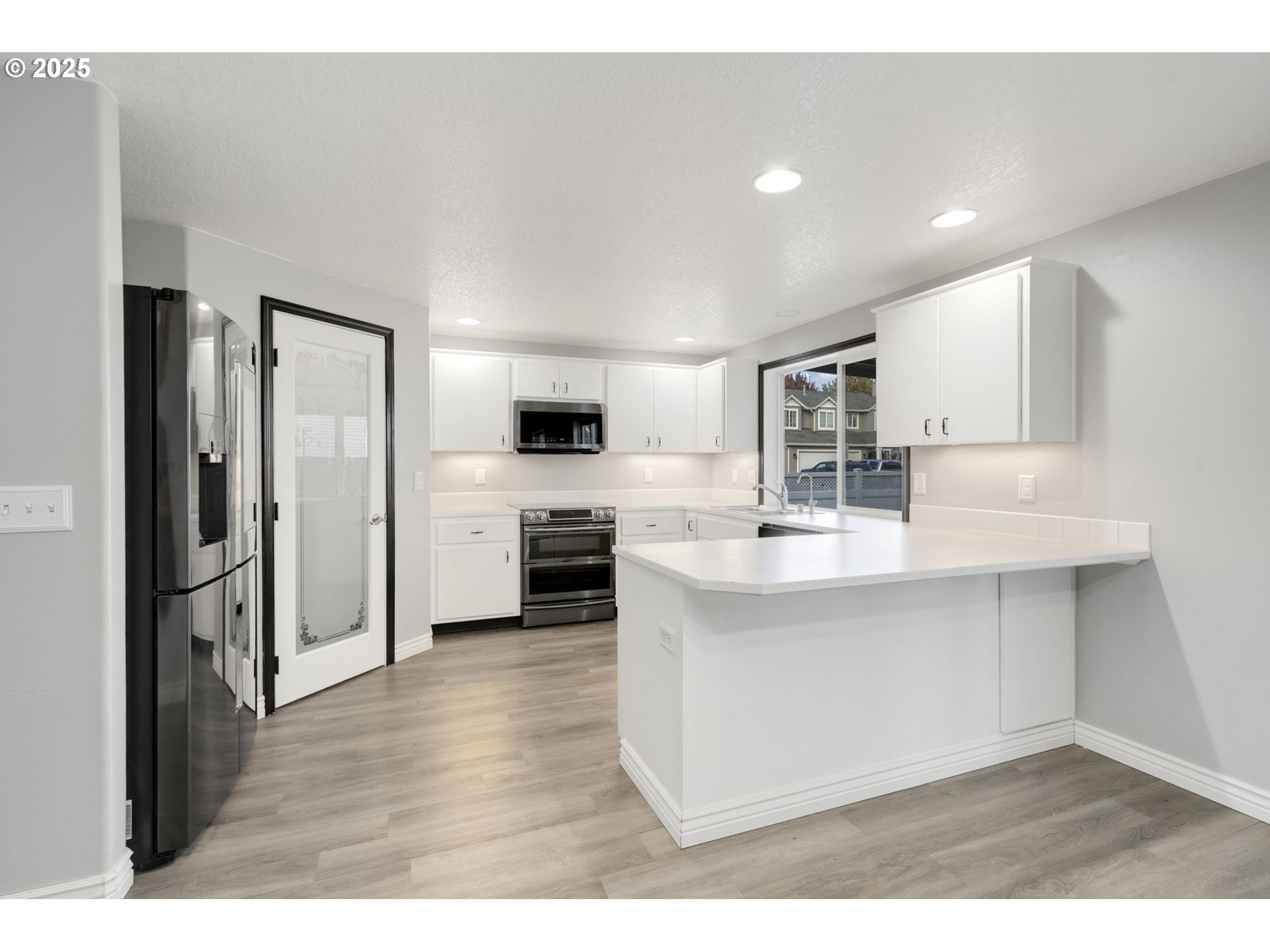 1311 Northwest 26th Avenue Battle Ground, WA 98604 - Photo 18 of 44 a kitchen with stainless steel appliances a sink a stove a refrigerator and cabinets