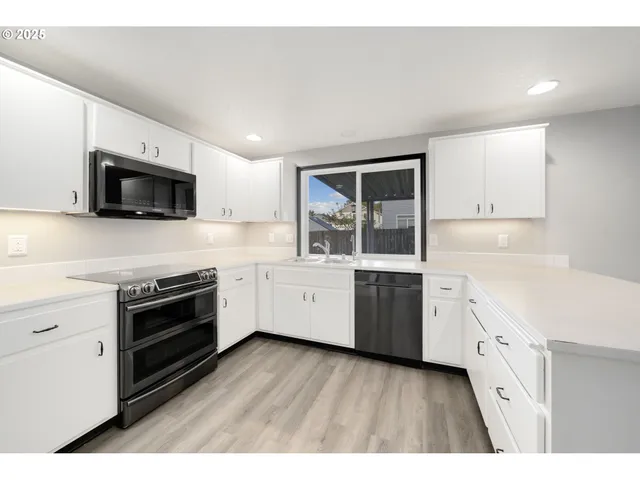 a kitchen with granite countertop a stove top oven sink and cabinets