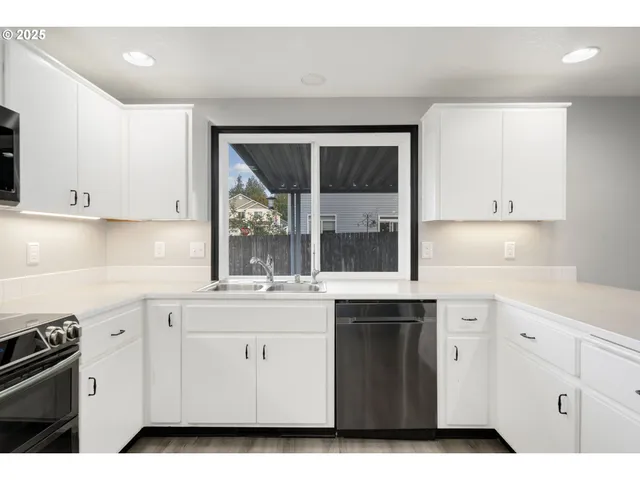 a kitchen with white cabinets and white appliances