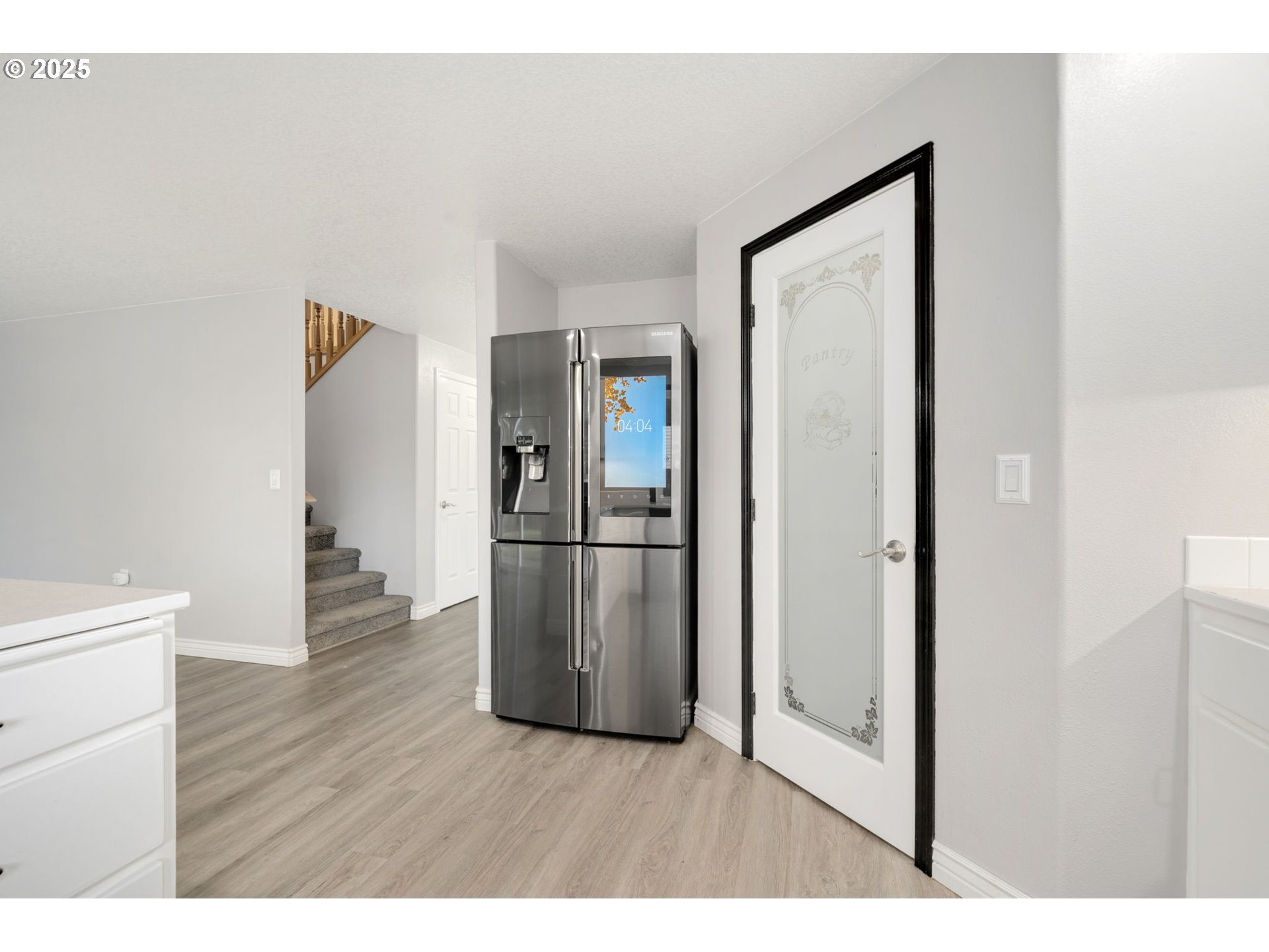 1311 Northwest 26th Avenue Battle Ground, WA 98604 - Photo 21 of 44 a hallway with wooden floor electronic appliances and stairs