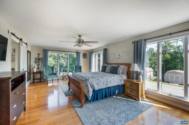 a view of a hallway with wooden floor and a living room