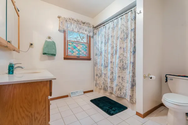 a bathroom with a toilet a sink and curtain