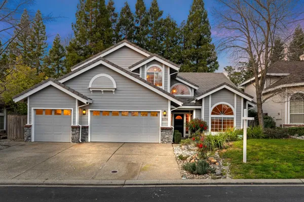 a front view of a house with garage and garden