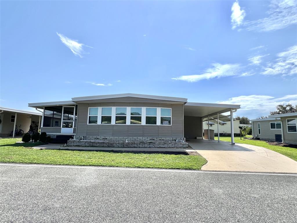 a front view of a house with a yard and potted plants