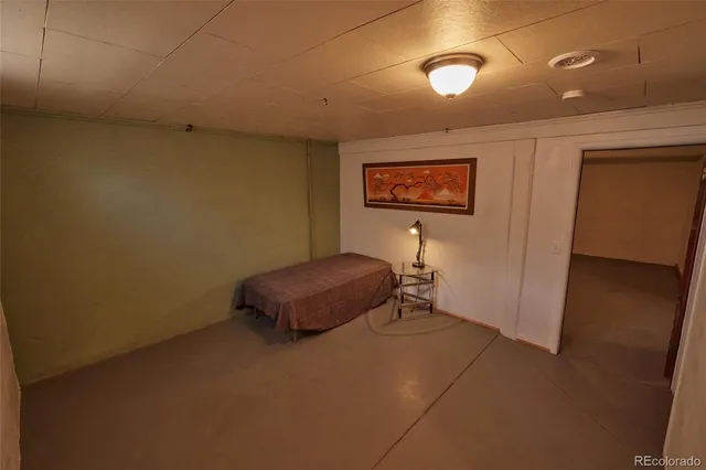 a room with a bed and a painting on the wall