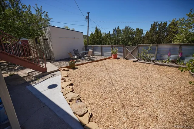 a backyard of a house with table and chairs