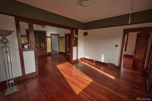 a hallway view with wooden floor and staircase