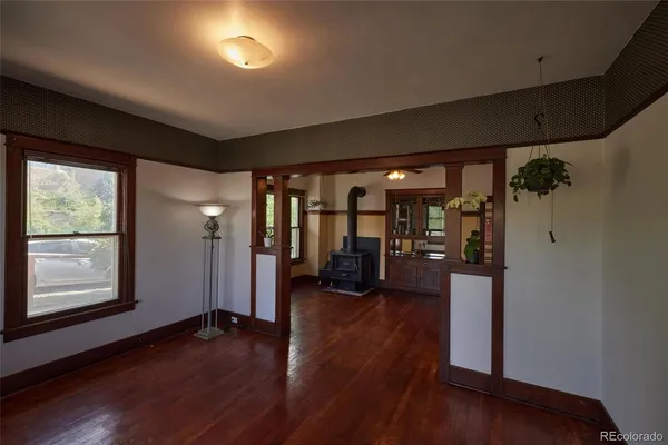 a view of a hallway with wooden floor and a bathroom
