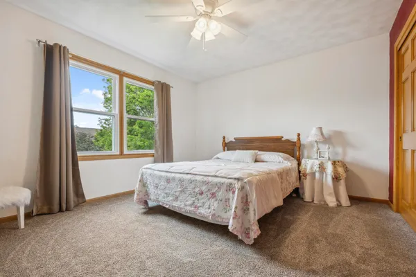a bedroom with a bed and a large window