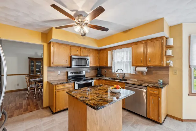 a kitchen with stainless steel appliances granite countertop a sink stove and refrigerator