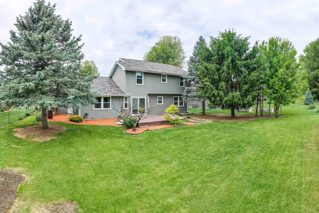 a view of a house with backyard and sitting area