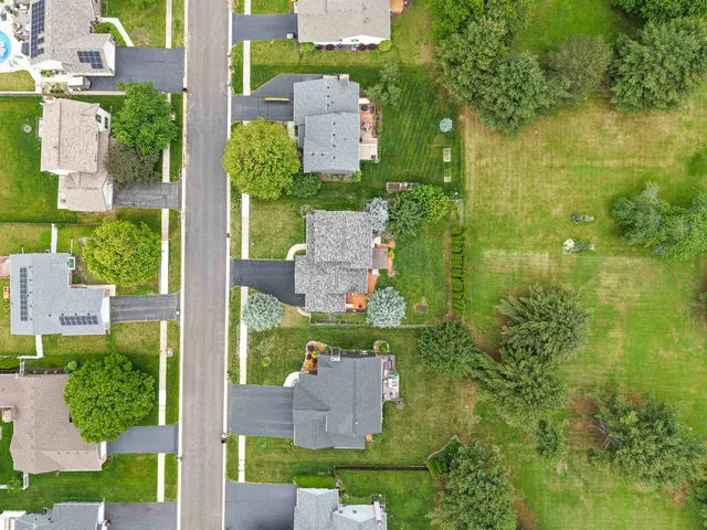 an aerial view of residential house with outdoor space and trees all around