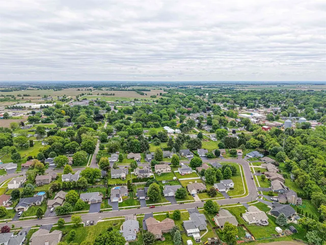 an aerial view of residential houses with outdoor space and trees