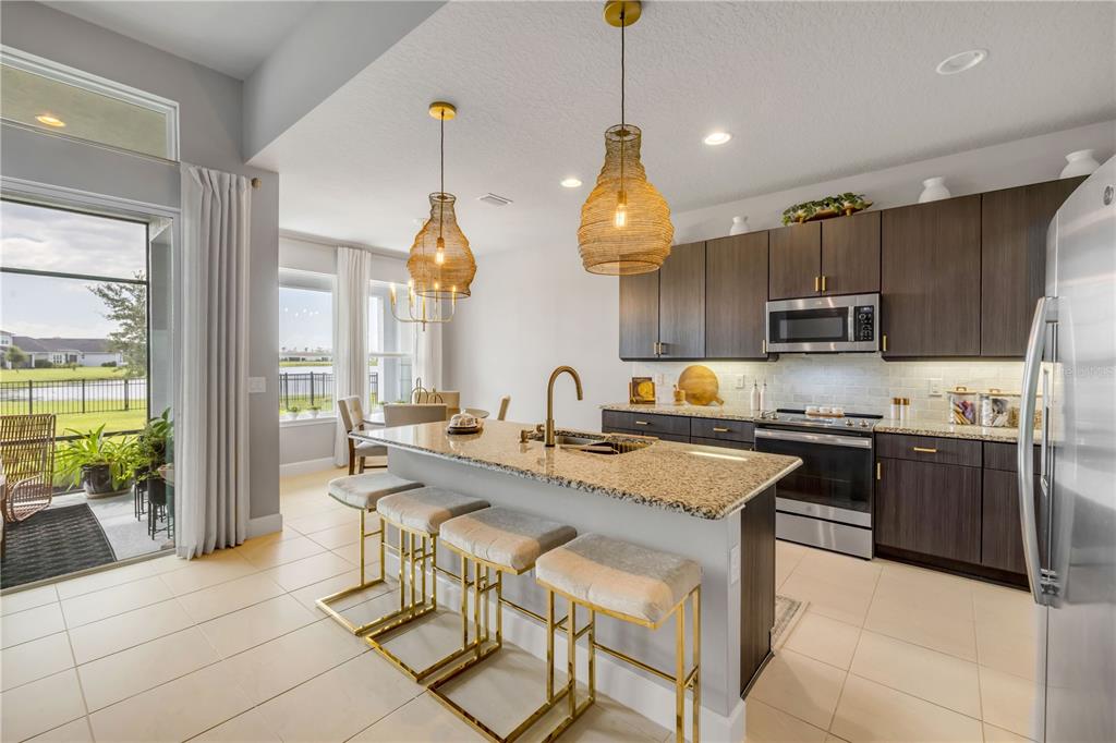 195 Azure Mist Way Daytona Beach, FL 32124 - Photo 18 of 63 a kitchen with stainless steel appliances granite countertop a stove a sink a oven a dining table and chairs