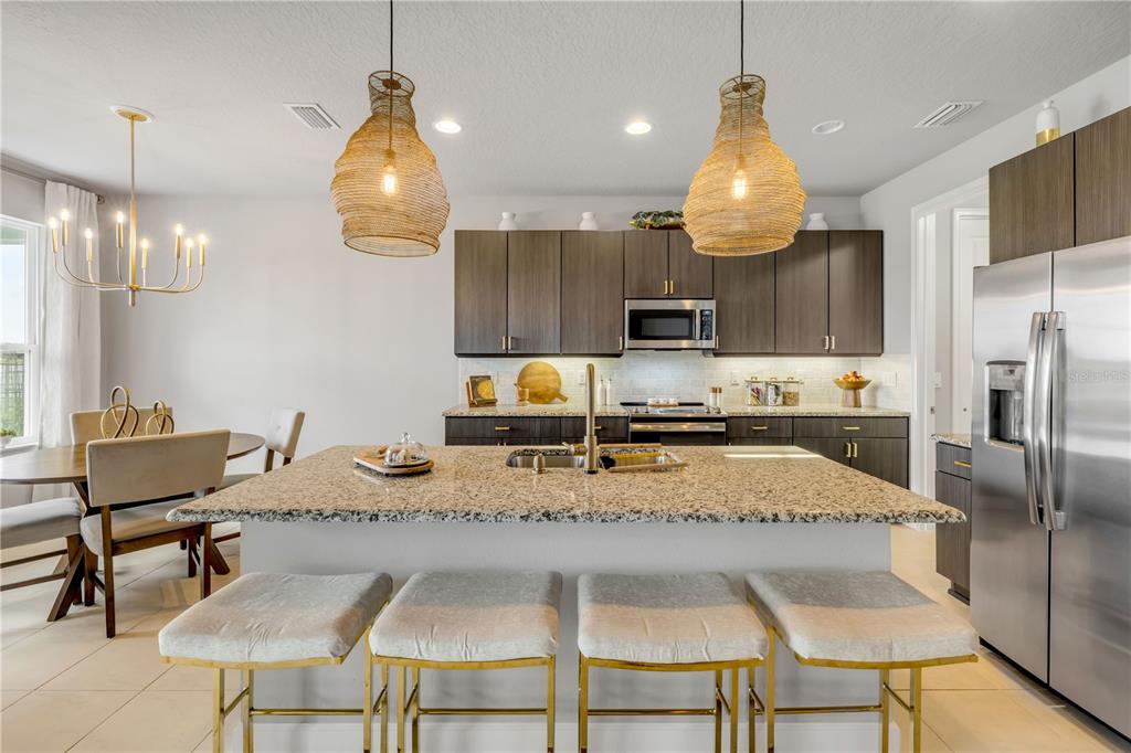 195 Azure Mist Way Daytona Beach, FL 32124 - Photo 19 of 63 a kitchen with granite countertop a table chairs stove and refrigerator