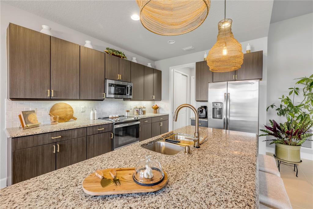 195 Azure Mist Way Daytona Beach, FL 32124 - Photo 20 of 63 a kitchen with granite countertop a stove a sink and a microwave