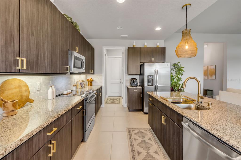 195 Azure Mist Way Daytona Beach, FL 32124 - Photo 23 of 63 a kitchen with kitchen island granite countertop a sink a counter top space appliances and cabinets
