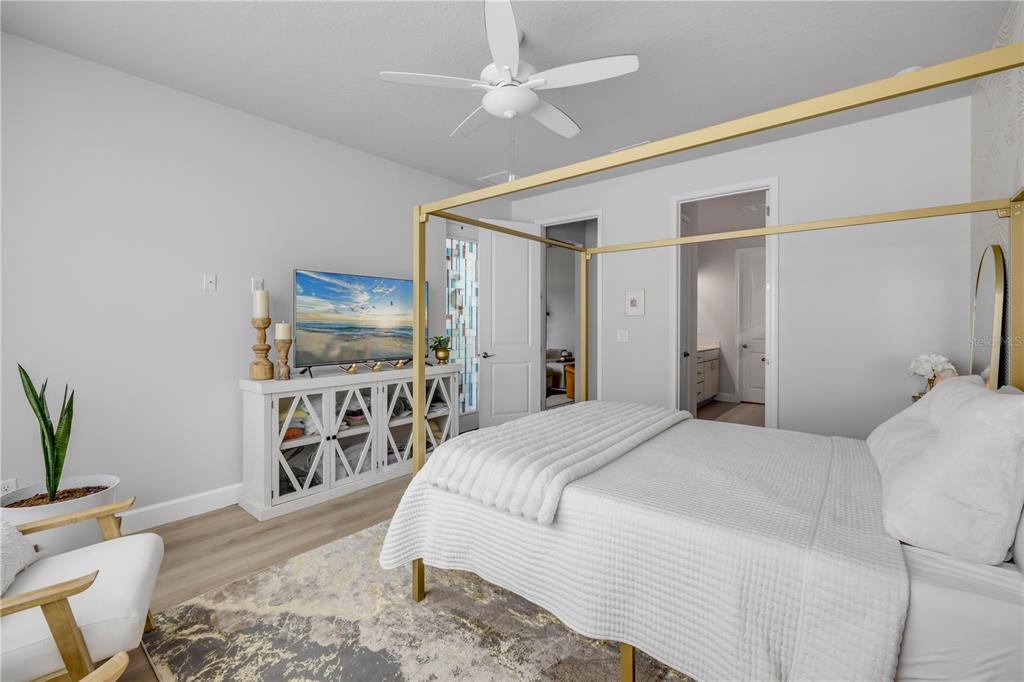 195 Azure Mist Way Daytona Beach, FL 32124 - Photo 33 of 63 a spacious bedroom with a bed a couch and a potted plant on the dresser