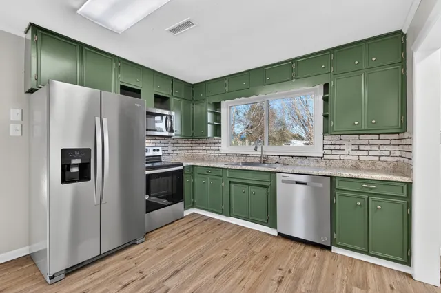 a kitchen with granite countertop a refrigerator and a sink