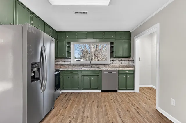 a kitchen with stainless steel appliances granite countertop a refrigerator and a sink