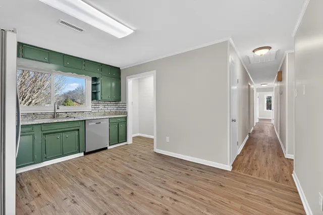 a kitchen with a refrigerator and wooden cabinets