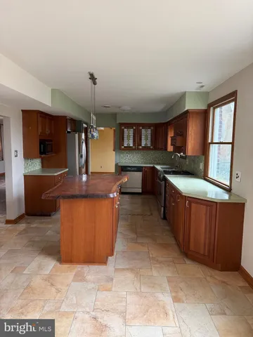 a large kitchen with stainless steel appliances granite countertop a stove and a sink