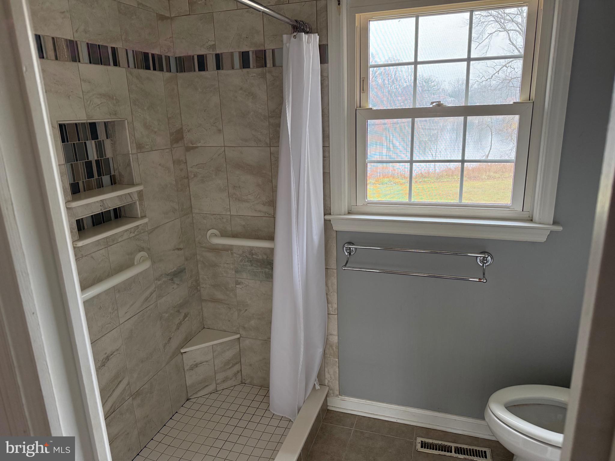 448 Lake Avenue Pitman, NJ 08071 - Photo 8 of 24 a bathroom with a window and a toilet