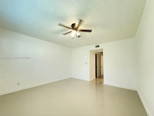 an empty room with a ceiling fan and a window