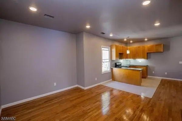 a view of an empty room with wooden floor