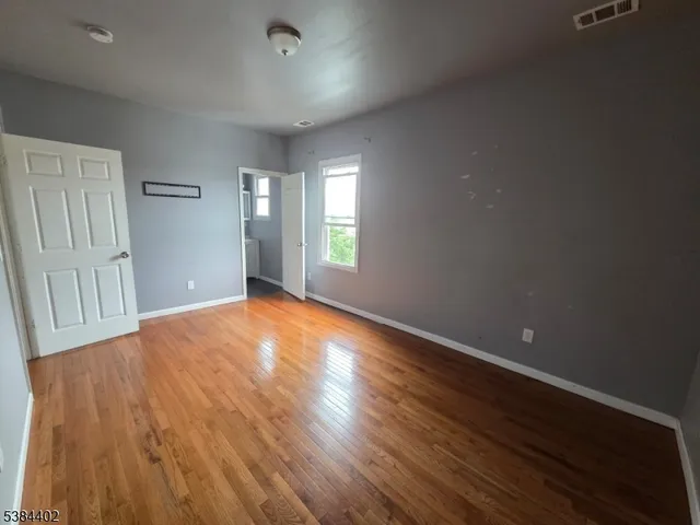 a view of a big room with wooden floor and windows