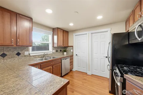 a kitchen with stainless steel appliances granite countertop a sink stove and refrigerator