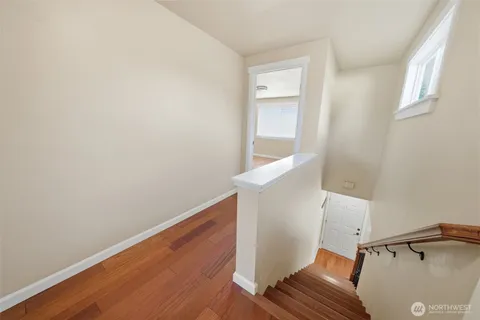 a view of an empty room with wooden floor