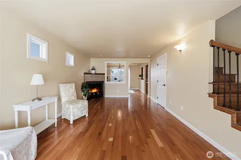 a view of a livingroom with wooden floor and furniture
